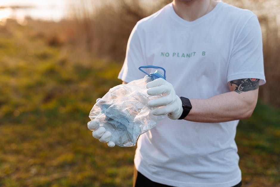 A person wearing blue jeans and white sneakers is crouching on an asphalt surface, holding a small, partially broken white ceramic object resembling a cup or bowl, which has visible cracks and still c